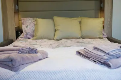 a bed with towels on top of it at The Fox Den in Rhayader