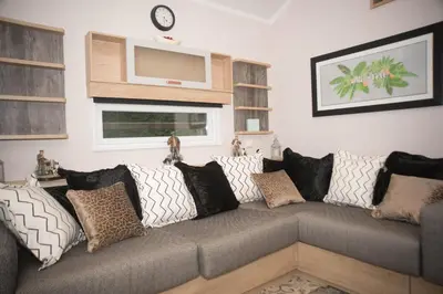 a living room with a gray couch with pillows at Woodland Escape in Nantmel