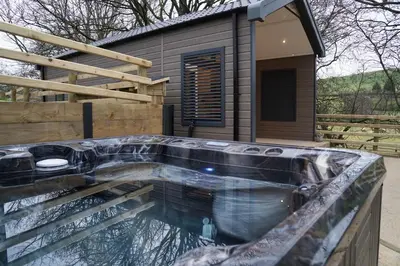 a swimming pool in front of a house at Woodland Escape in Nantmel