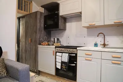 a kitchen with white cabinets and a stove top oven at Woodland Escape in Nantmel