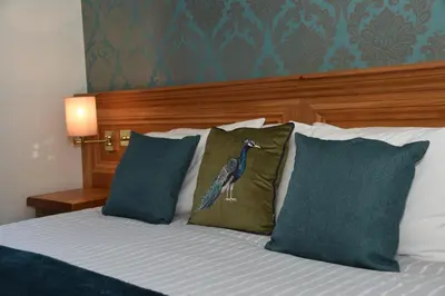 a bedroom with a bed with a bird on the pillow at Greyhound Hotel in Wales