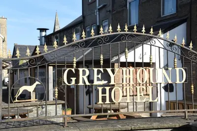 a gate with a sign that reads grey mound hotel at Greyhound Hotel in Wales