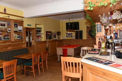 a bar with a pool table in a restaurant at Greyhound Hotel in Wales
