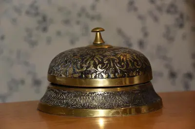 a brass bell sitting on top of a wooden table at Greyhound Hotel in Wales