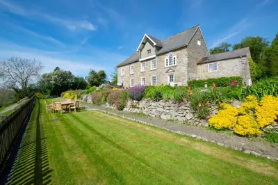 a large stone house with a garden in front of it at 3 Bed in Welshpool oc-bow122 in Welshpool