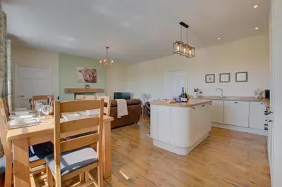 a kitchen and living room with a table and a dining room at 3 Bed in Welshpool oc-bow122 in Welshpool