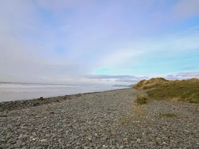a rocky beach with the ocean in the background at McAuliffe Lodge in Borth