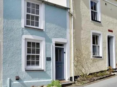 a blue house with white windows and a blue door at Driftwood in Aberdyfi