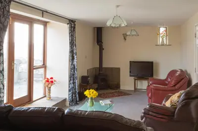 a living room with two couches and a television at Merlin Cottages in Llandovery