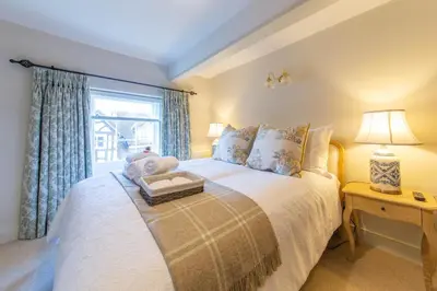 a bedroom with a bed with a teddy bear on it at Turford House, Ludlow in Ludlow