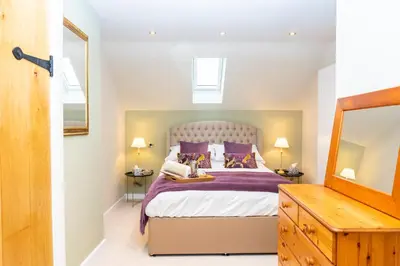 a bedroom with a large bed with purple pillows at The Patches in Shrewsbury