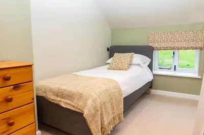 a small bedroom with a bed and a window at The Patches in Shrewsbury