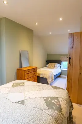 a bedroom with two beds and a dresser in it at The Patches in Shrewsbury
