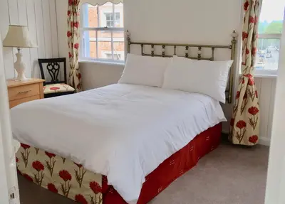 a bedroom with a bed with a red and white comforter at 4BedHouse Leominster Hiking Castles Sleeps7 Wifi in Leominster