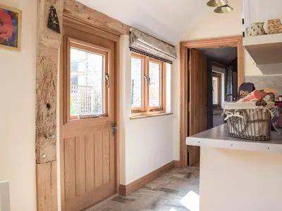 a kitchen with a wooden door and a counter at Badgers Den - Uk32084 in Dorstone