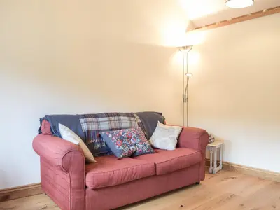 a red couch with pillows on it in a living room at Gooses Roost - Uk32096 in Dorstone