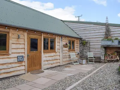 a wooden cabin with a door and a patio at Gooses Roost - Uk32096 in Dorstone