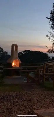 a building with a fire in it at sunset at Lle Mary - Beautiful views, Hot tub, Secluded, Dog Welcome, Barmouth in Llanddwywe