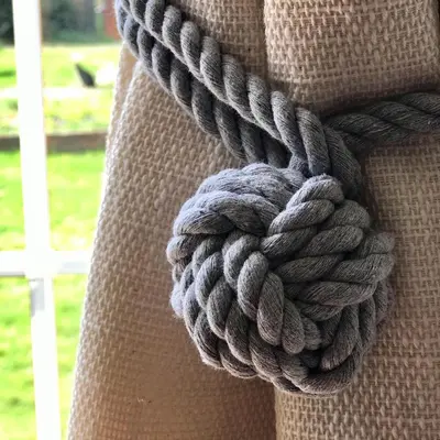 a coil of rope on the side of a curtain at Archers Cottage in Leominster