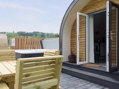 a patio with a table and bench on a house at Cain Pod Vip in Llanfyllin