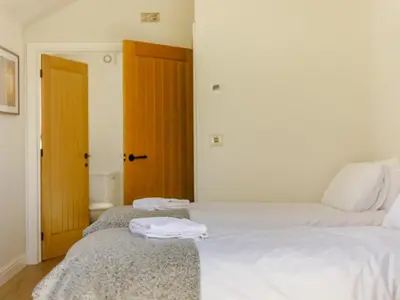a bedroom with two beds with towels on them at Barn Owls Rest in Clyro