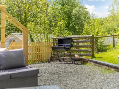 a grill in a yard next to a fence at Barn Owls Rest in Clyro
