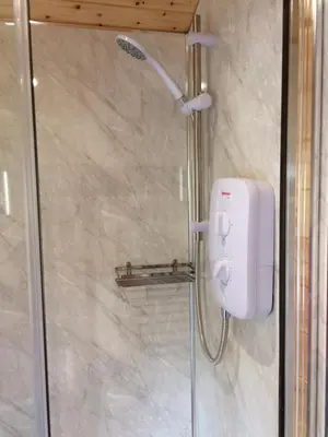 a shower in a bathroom with a white soap dispenser at Cwt y Bugail in Barmouth