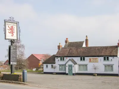 a white building with a sign in front of it at 1 Royal Oak Cottages in Shrewsbury