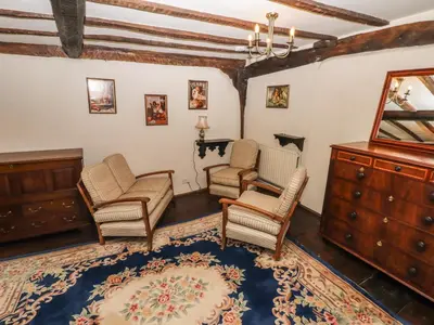 a living room with chairs and a dresser at Top Farm House in Oswestry