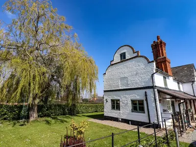 an old white house with a tree in the yard at Top Farm House in Oswestry