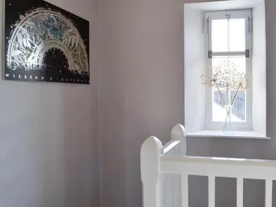 a white staircase with a vase of flowers in a window at The Mill House, The Square in Talgarth