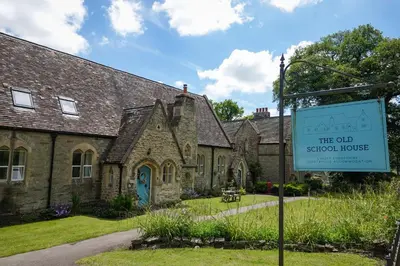 an old school house with a sign in front of it at The old school house in Burwarton