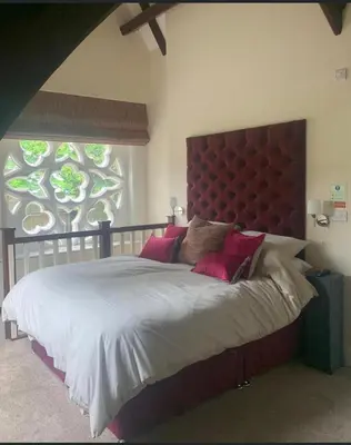 a bedroom with a large bed with a large window at The old school house in Burwarton