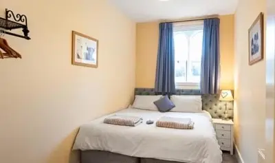 a bedroom with a bed with two pillows on it at The old school house in Burwarton
