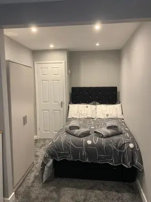 a bedroom with a bed with a black headboard at 6 Tai Isa, A Hidden Gem in Barmouth