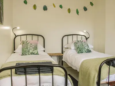 two beds in a room with leaves on the wall at Willow View in Shrewsbury
