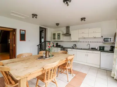 a kitchen with a wooden table and chairs at Caecrwn in Brecon