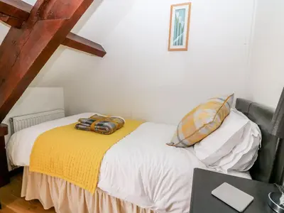 a bedroom with a bed with a yellow blanket at Caecrwn in Brecon