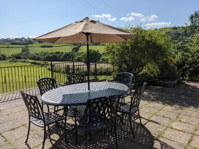 a table and chairs with an umbrella on a patio at Caecrwn in Brecon