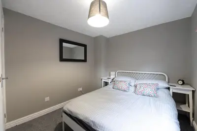 a bedroom with a white bed and a mirror at Coach House, Shrewsbury Town in Shrewsbury
