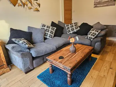 a living room with two couches and a coffee table at Ridge And Tides in Fairbourne