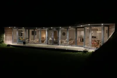 a house lit up at night with lights at Wilderness Lodge in Oswestry