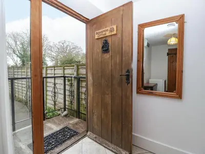 an open door to a balcony with a mirror at Beekeeper's Cottage in Leominster