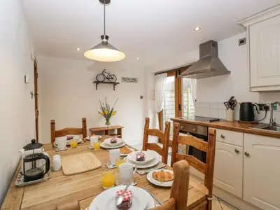 a kitchen with a table and chairs and a dining room at Beekeeper's Cottage in Leominster