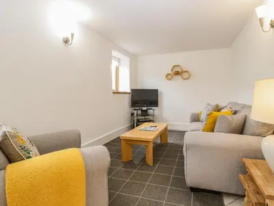 a living room with two couches and a tv at Beekeeper's Cottage in Leominster
