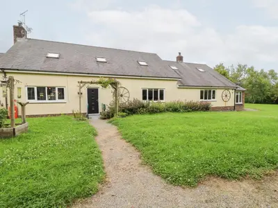 a house with a grass yard in front of it at Tynewydd Fields in Lampeter