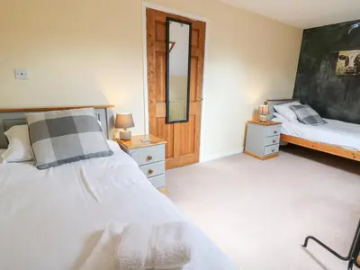 a bedroom with a bed and a mirror at Tynewydd Fields in Lampeter