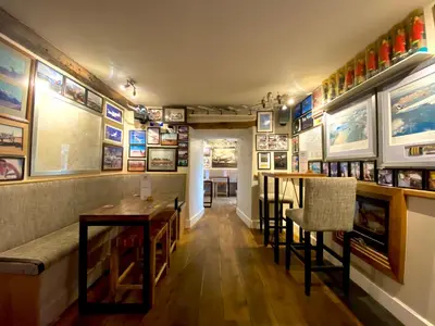 a restaurant with tables and pictures on the walls at Castle Cottage Inn in Harlech