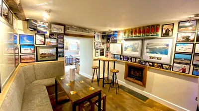 a restaurant with a table and some pictures on the wall at Castle Cottage Inn in Harlech