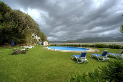 a group of chairs sitting in the grass by a pool at Portmeirion Village & Castell Deudraeth in Porthmadog